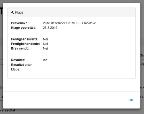 Bildet viser skjermbilde av kvitteringen du får opp når du har registrert en klage. Øverst er det et lite ikon som viser en liten hammer, lik den som brukes av dommere i retten, og det står «Klage» ved siden av ikonet. Så listes informasjon om prøven det er klaget på: Prøvenavn, dato for når klagen er opprettet, om klagen er ferdigsensurert, om den er ferdigbehandlet, om brev er sendt, resultat på prøven og resultat etter klage. Eksempelet som er lagt til er ikke behandlet, og det er derfor ikke ført opp et resultat etter klage (dette feltet er blankt i eksempelet). Nederst er det en hvit knapp med blå skrift, der det står «OK».