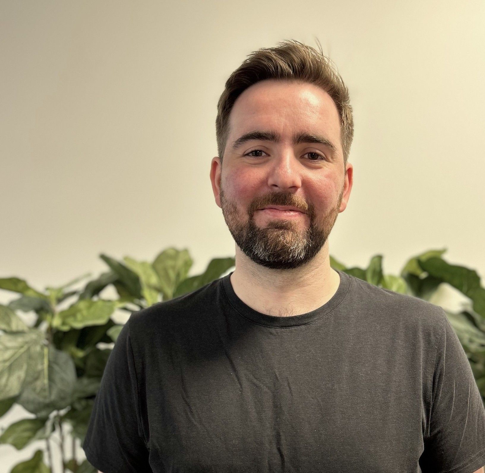Patrick Vestad ser mot kamera foran grønne planter.