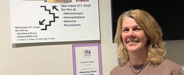 En kvinne i halvprofil smiler til kamera.