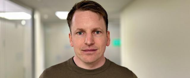 Mann som ser mot kamera
