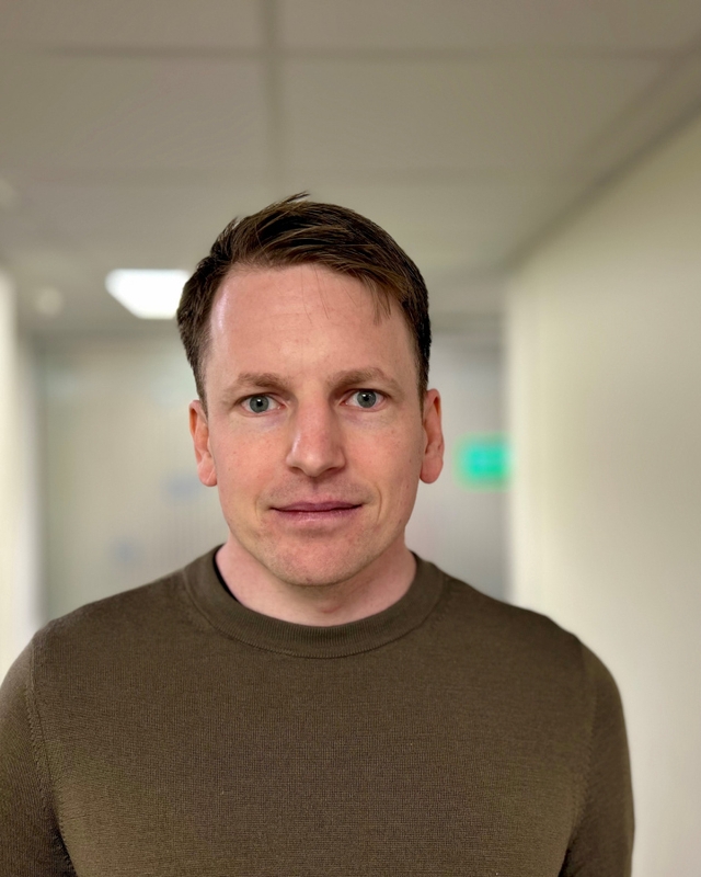 Mann som ser mot kamera