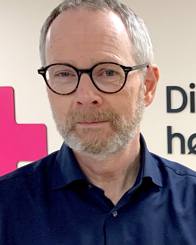 Portrettbilde av mann med sorte briller og skjegg.