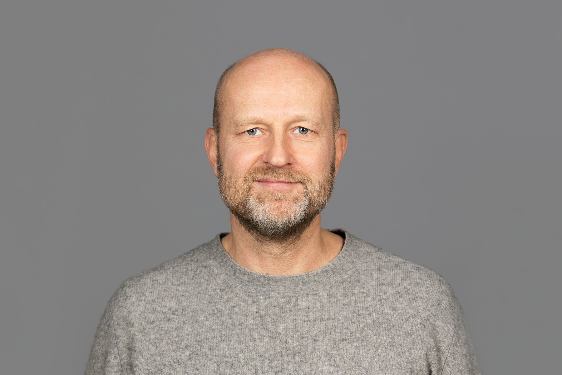 Portrett av Petter Bae Brandtzæg i en grå genser mot en grå bakgrunn.