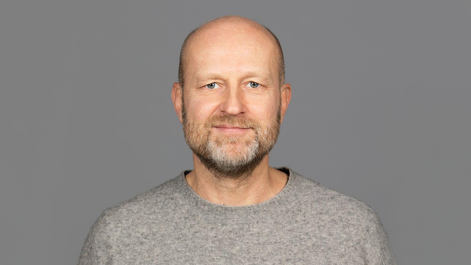 Portrett av Petter Bae Brandtzæg i en grå genser mot en grå bakgrunn.