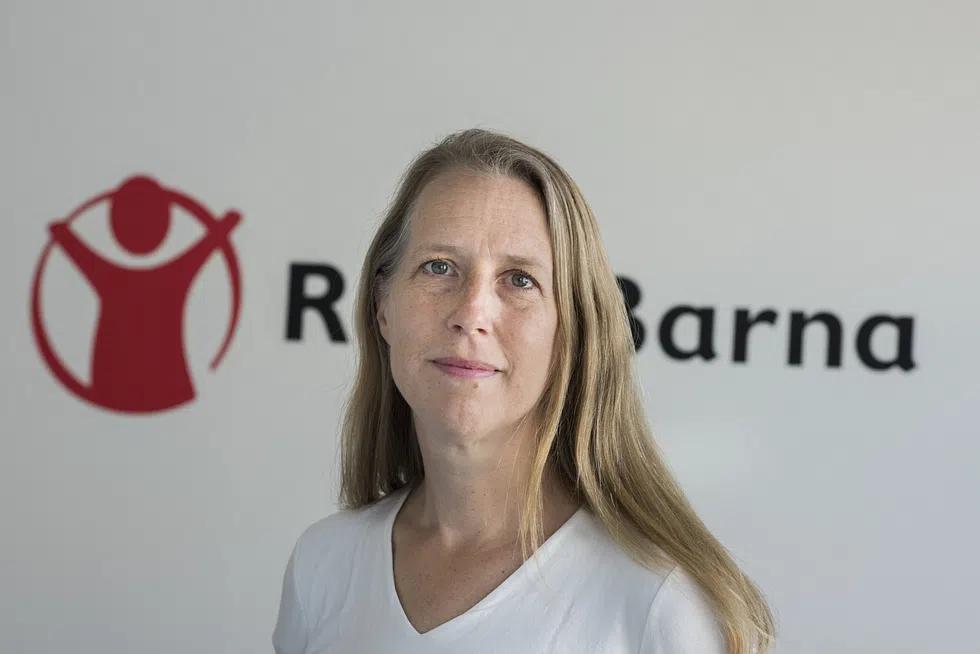 Kaja Hegg står foran Redd Barna-logoen og ser mot kameraet.