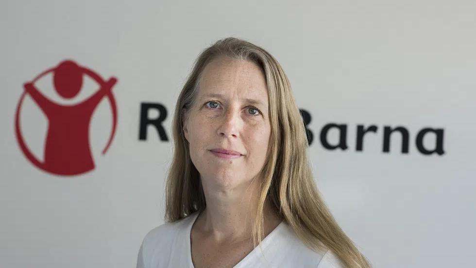 Kaja Hegg står foran Redd Barna-logoen og ser mot kameraet.