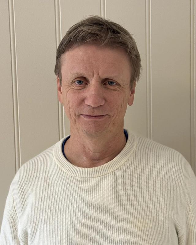 Mann som ser mot kamera