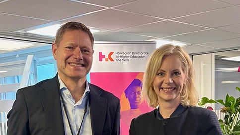 Mann og dame som ser i kameraet og smiler. Begge er pent kledd.