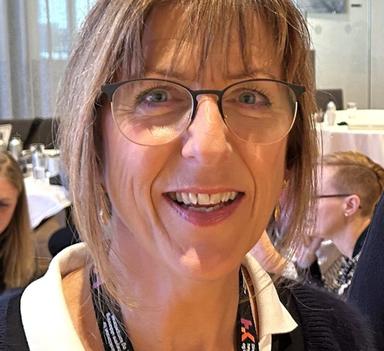 Portrett av en kvinne med briller og mellombrunt hår.