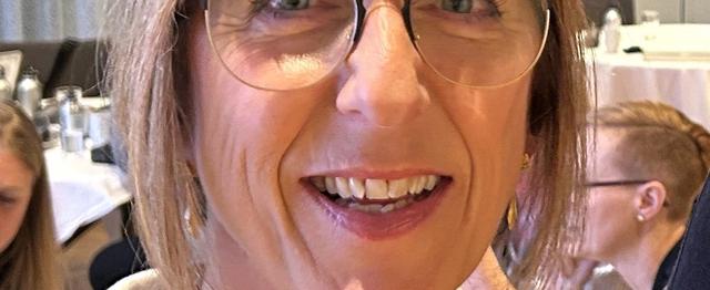 Portrett av en kvinne med briller og mellombrunt hår.