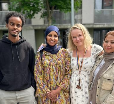 Seks personer står på rekke. De ser i kamera og smiler.