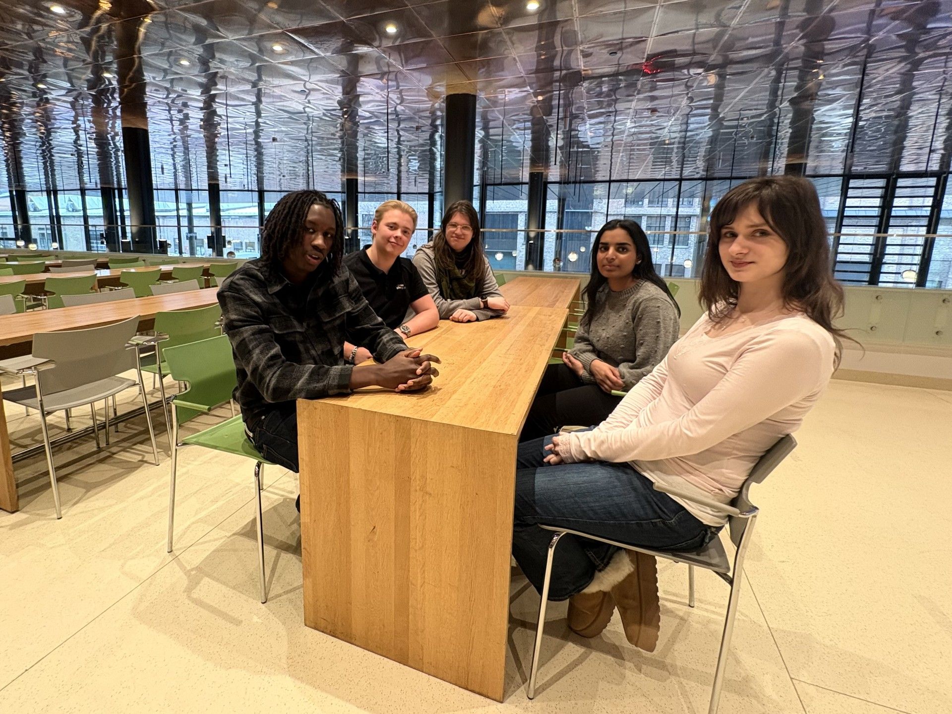 Fem elever sitter rundt et bord 