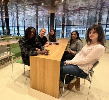 Fem elever sitter rundt et bord