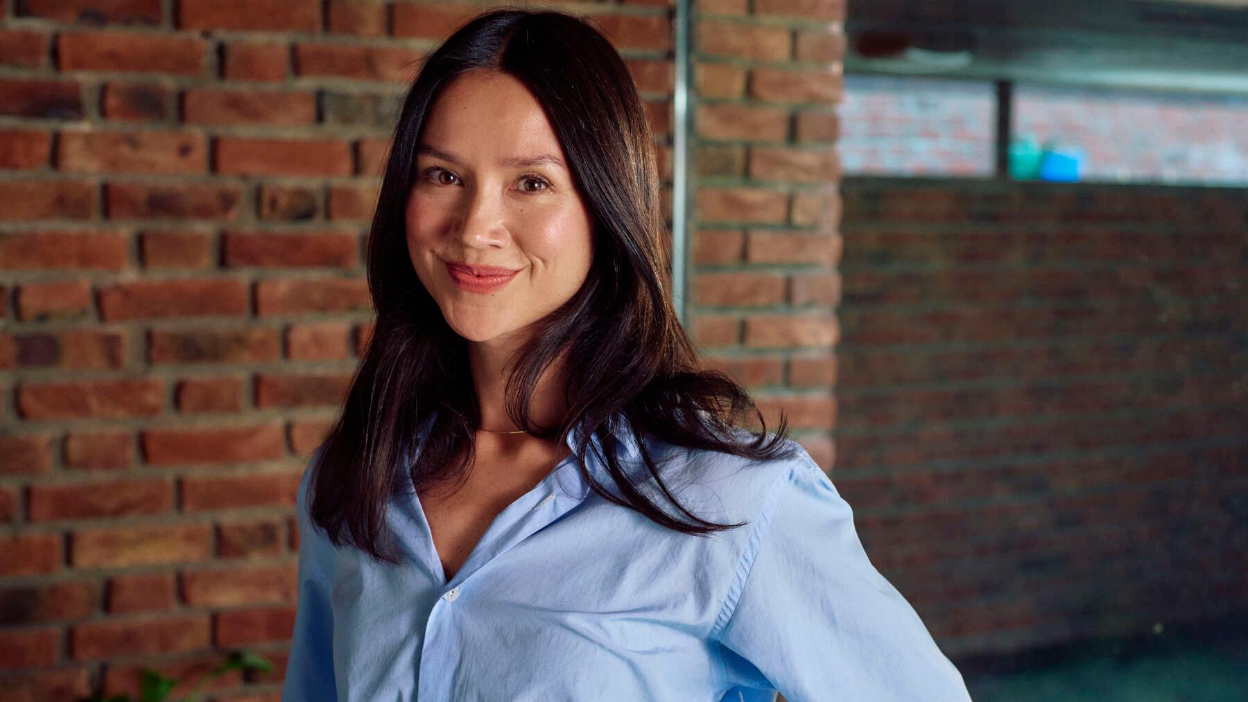 Sara Seehuus ser mot kamera foran en nøytral bakgrunn.