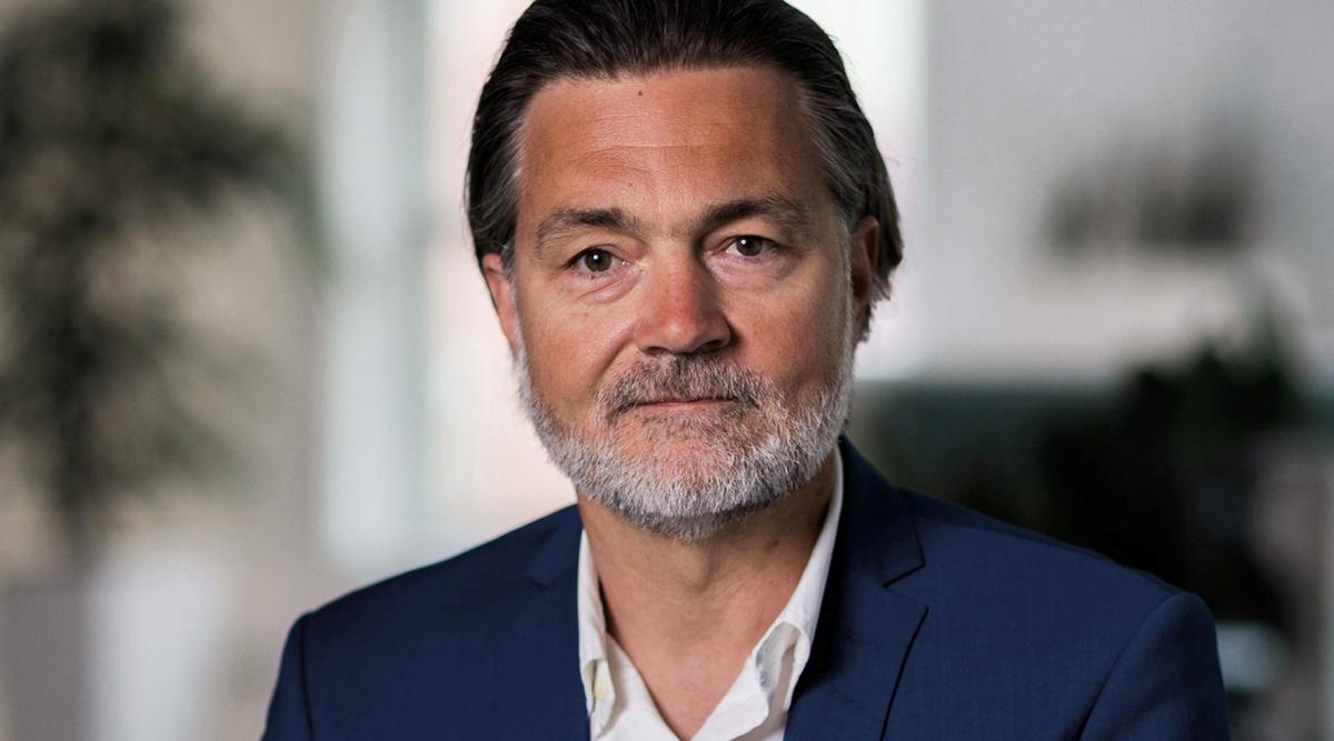 Mann i blå dress i halvprofil.