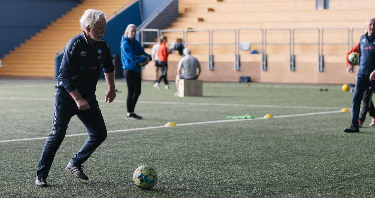 Eldre mann gjør seg klar til å sparke fotball i mål.