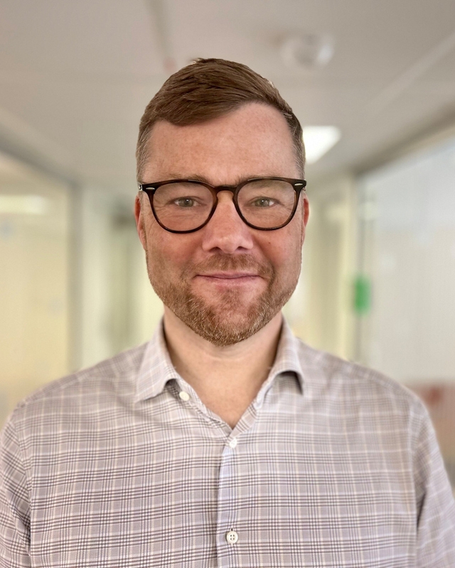 Mann som ser mot kamera