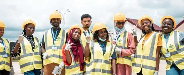 Men and women wearing face masks, reflective vests and helmets