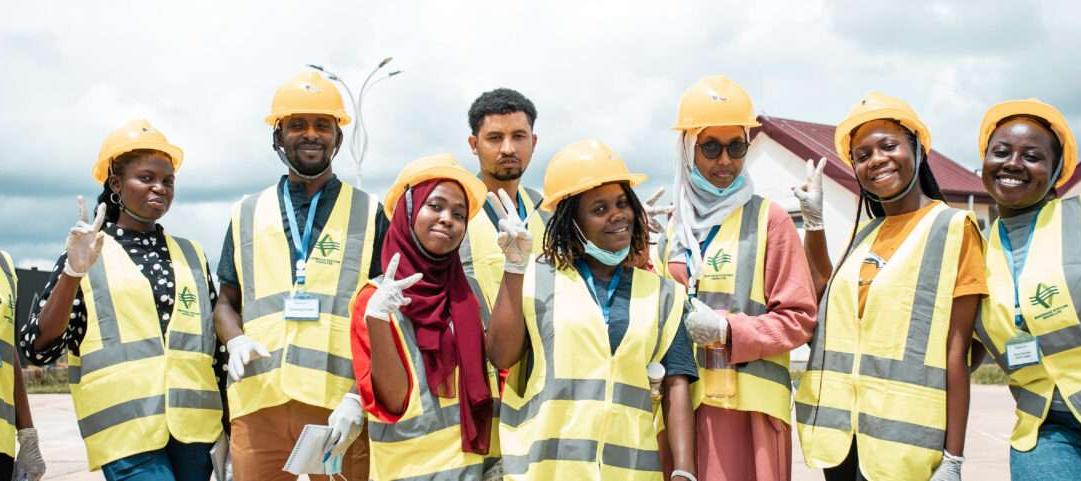 Men and women wearing face masks, reflective vests and helmets 