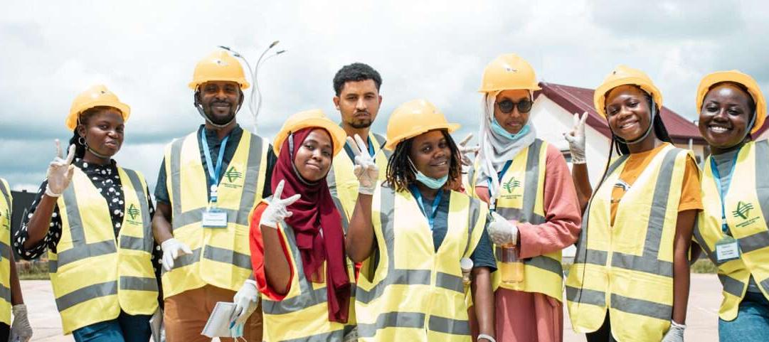 Men and women wearing face masks, reflective vests and helmets