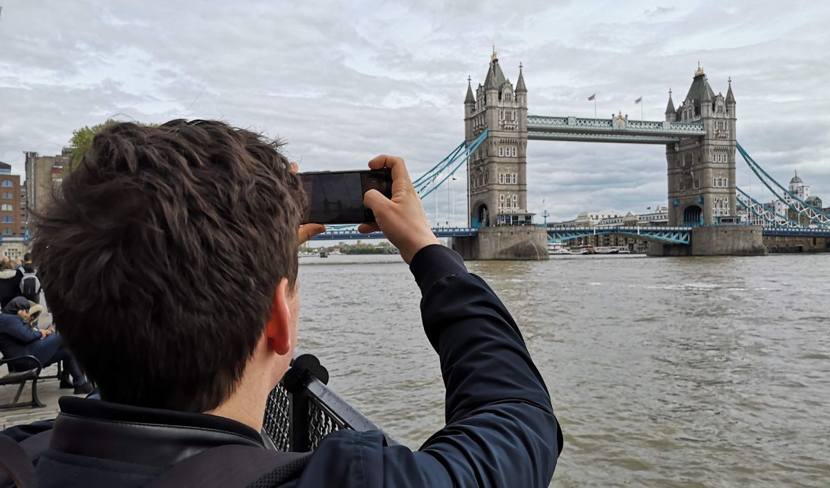 En ung mann fotograferer Tower Bridge i London