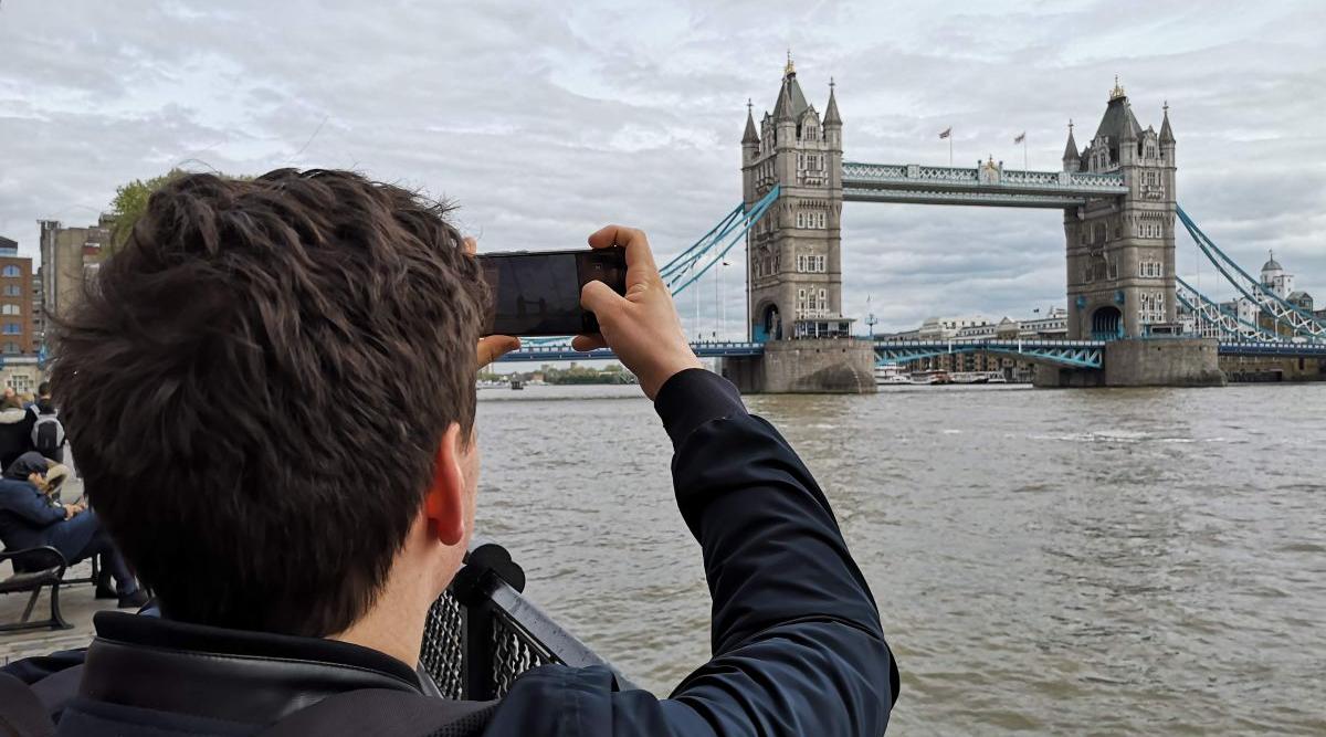 En ung mann fotograferer Tower Bridge i London