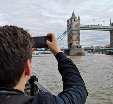 En ung mann fotograferer Tower Bridge i London