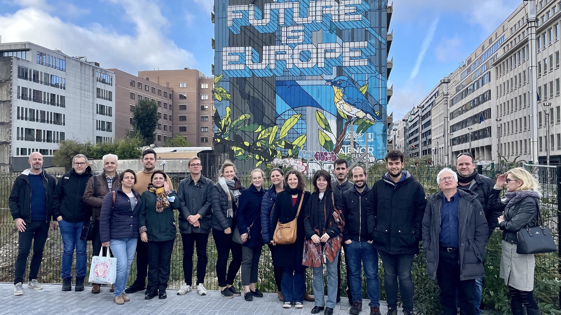 Kvinner og menn står foran en bygning i Brussel med teksten "The Future is Europe" tagget på veggen som en maleri.