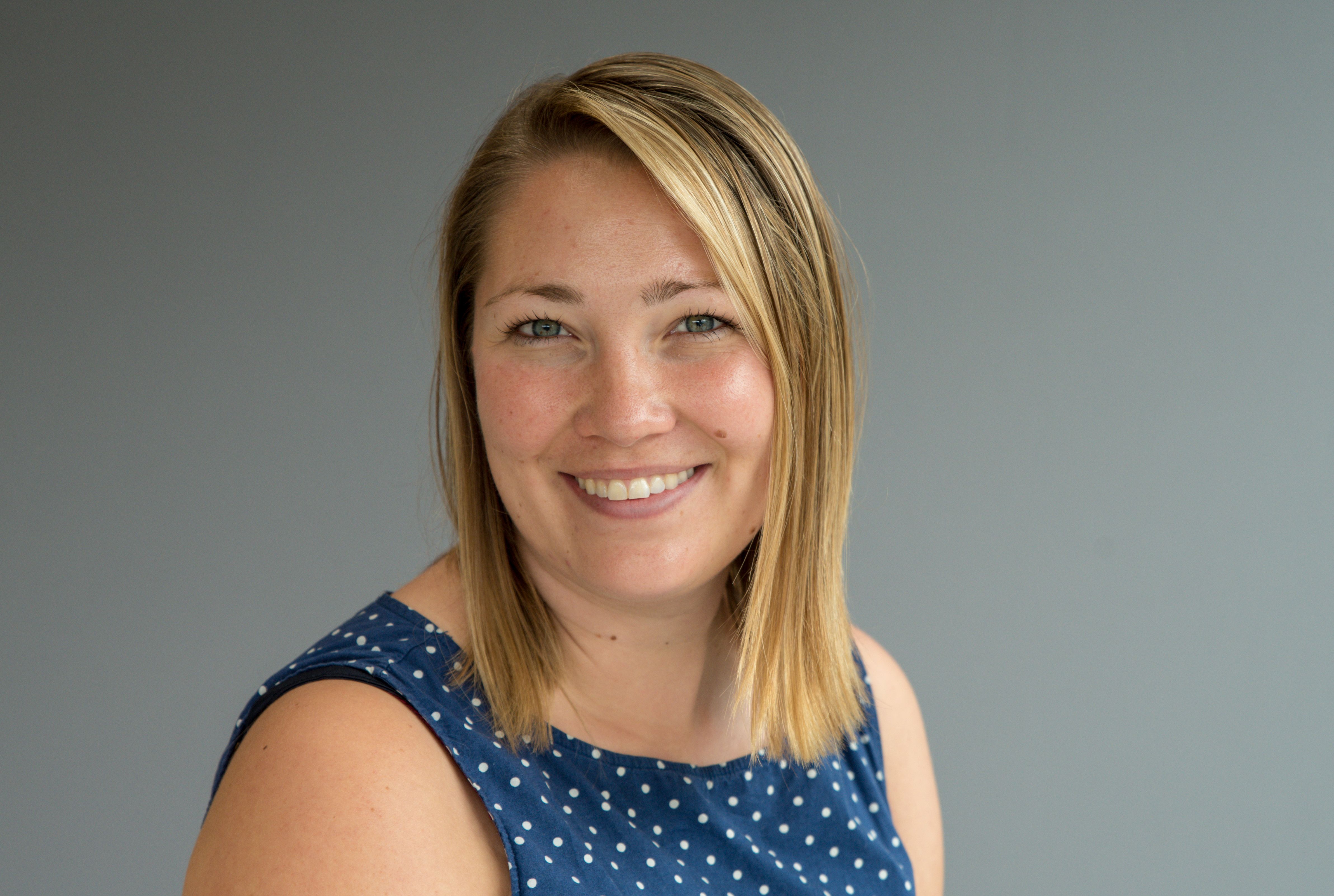 Kvinner i halvprofil ser i kamera og smiler.