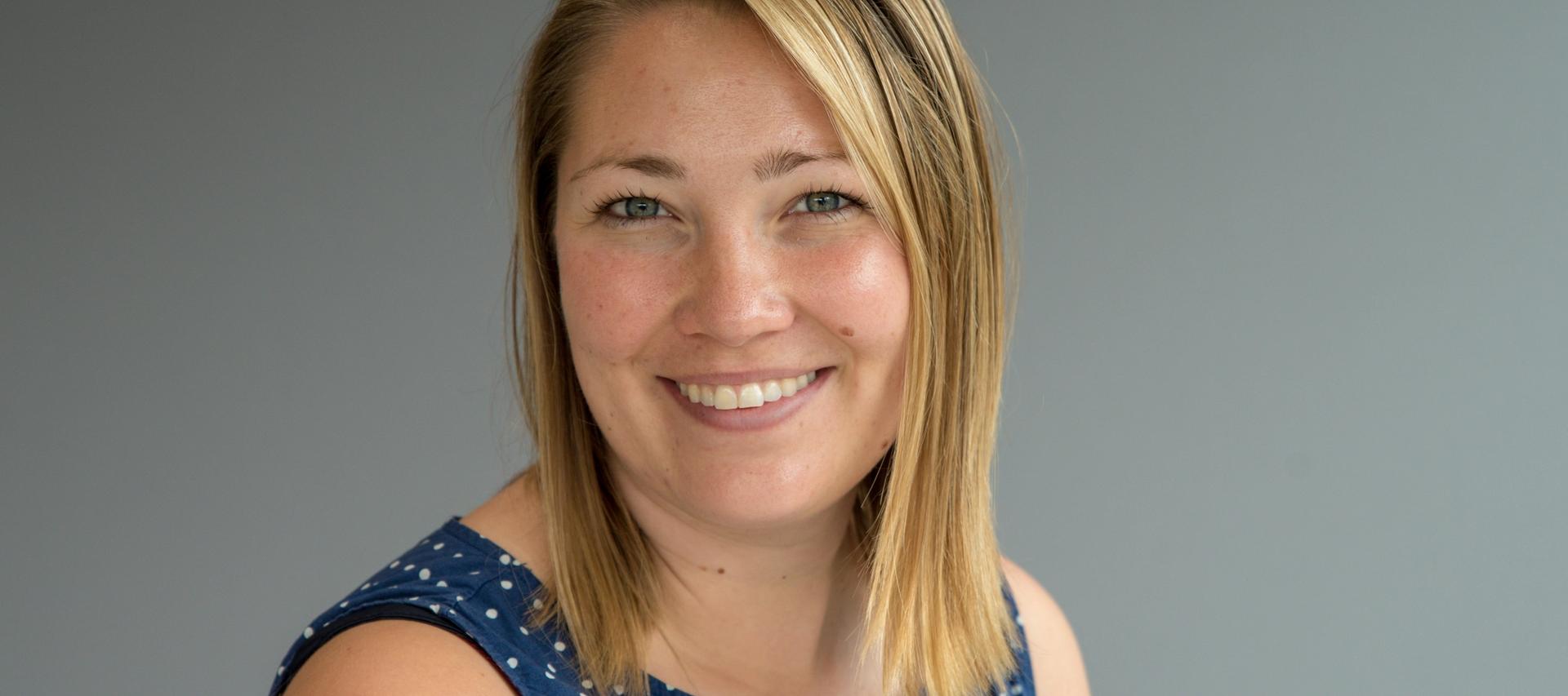 Kvinner i halvprofil ser i kamera og smiler.