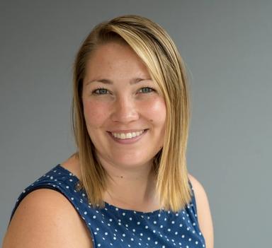 Kvinner i halvprofil ser i kamera og smiler.