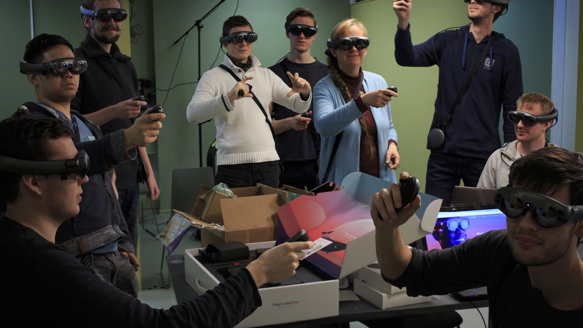 Ni personer, kvinner og menn, i et klasserom. Alle har på seg VR-briller.