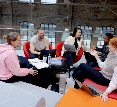 Fem studenter sittende i samtale