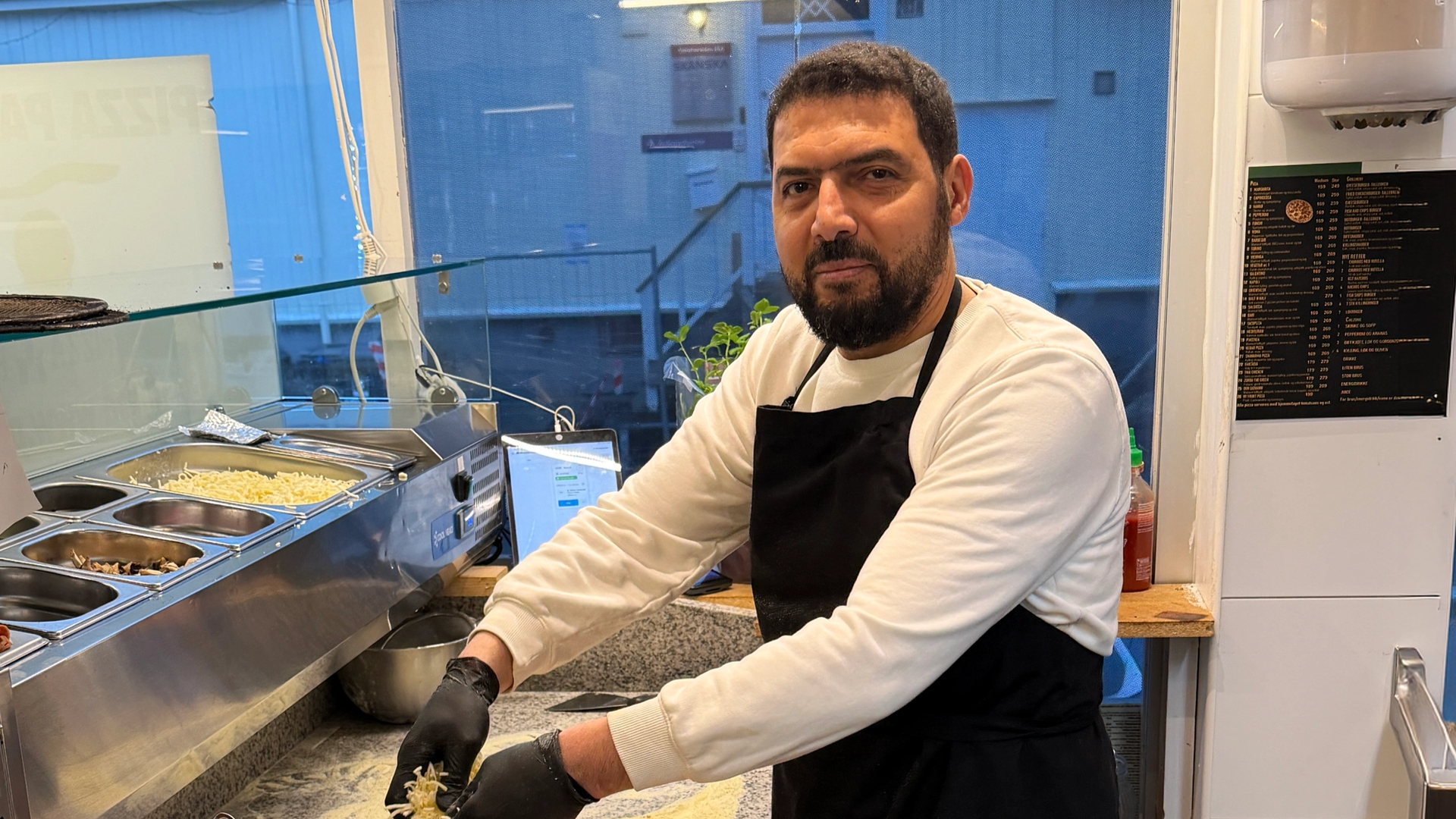 Mann baker pizza i sin egen pizzarestaurant.