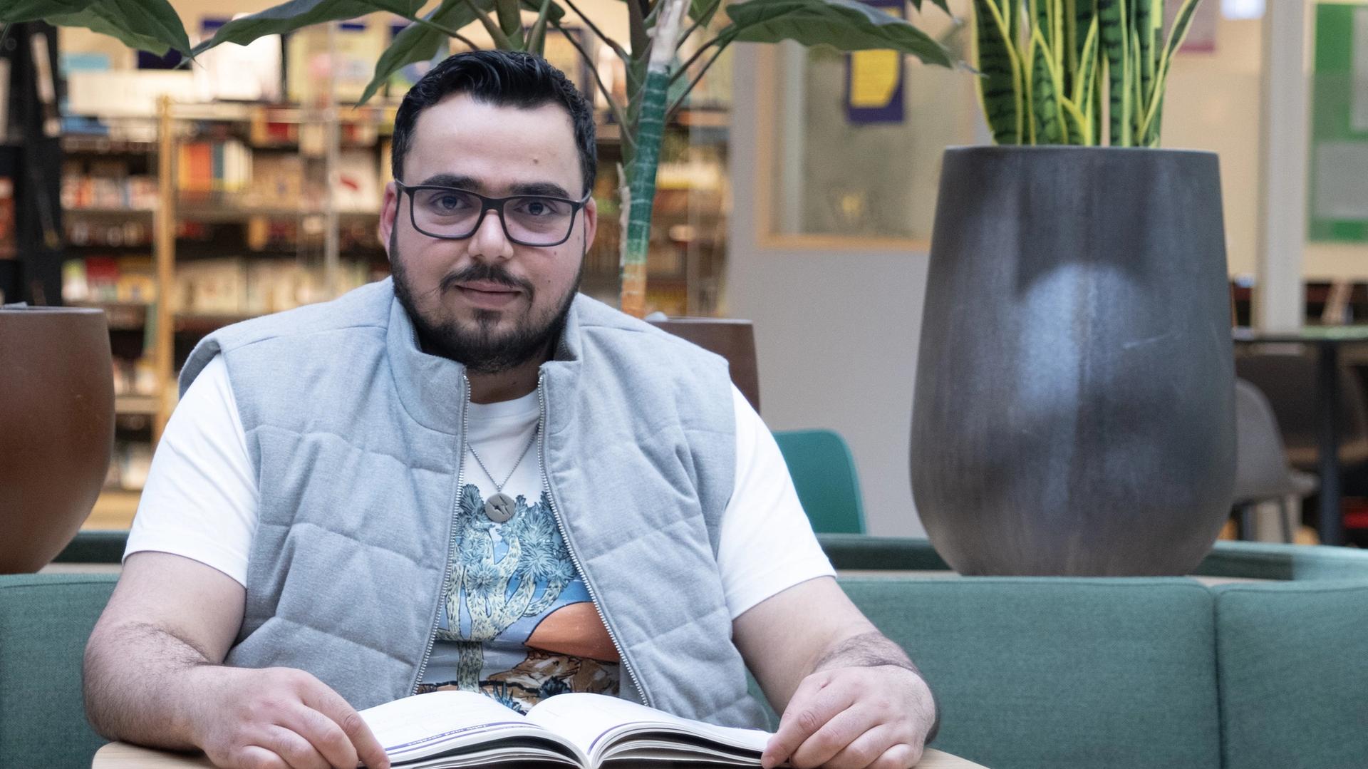 Ahmad Alshahad deltok på livsmestringskurset ved Oslo VO Helsfyr. På bildet sitter han ved et bord med en åpen bok i et læringsmiljø.