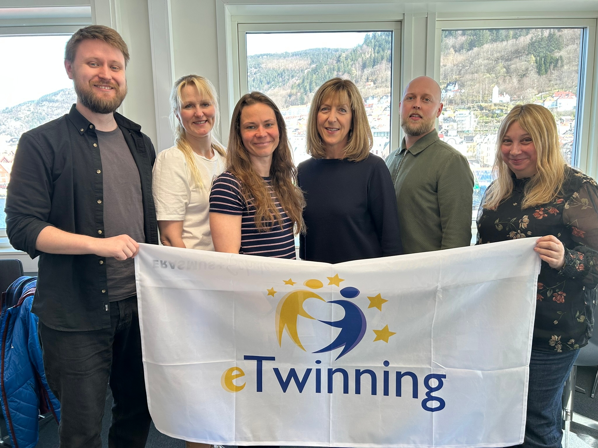 To menn og fire kvinner smiler til kameraet.