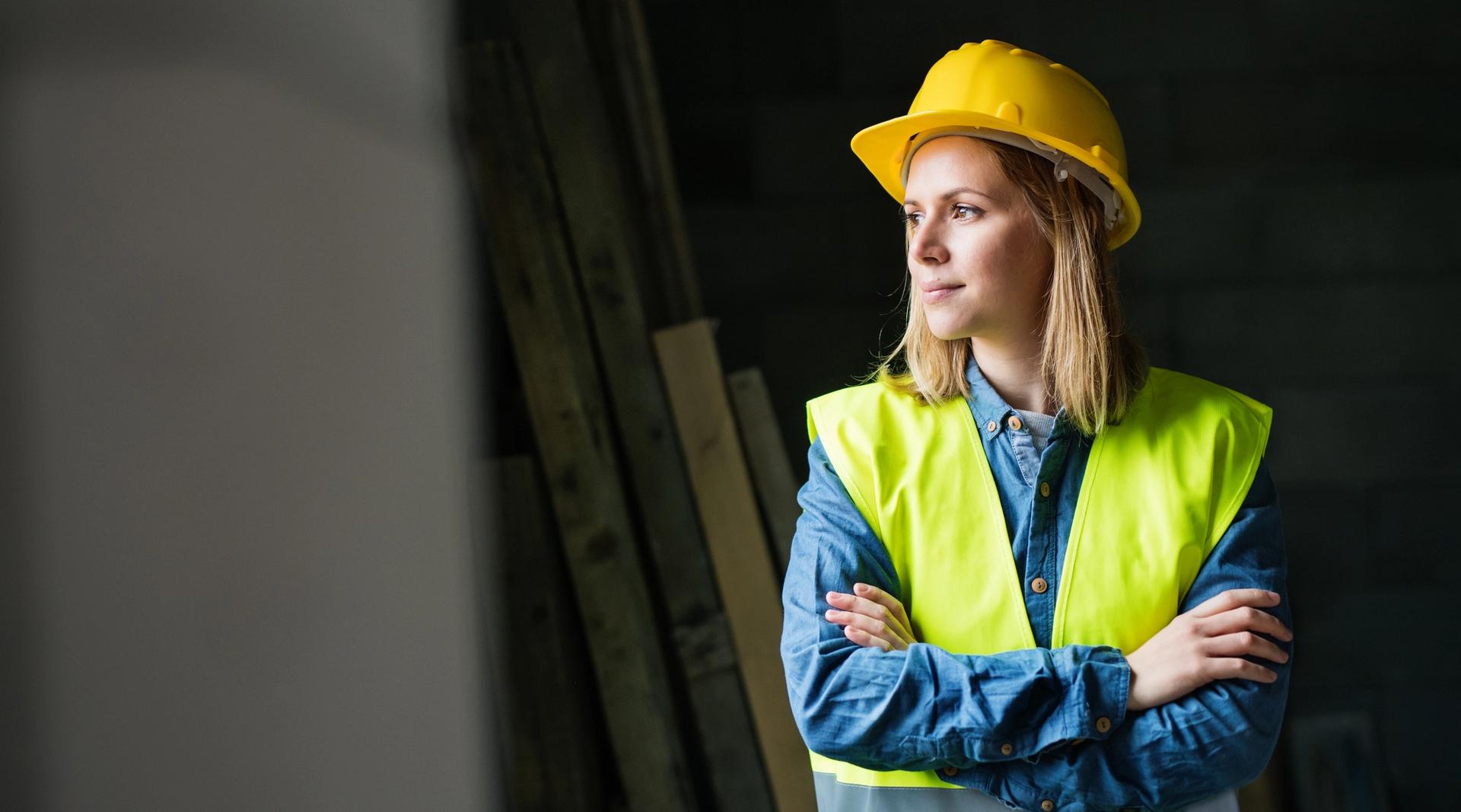 Kvinnelig håndverker med hjelm på byggeplass