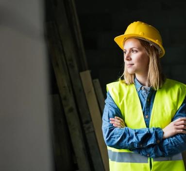 Kvinnelig håndverker med hjelm på byggeplass