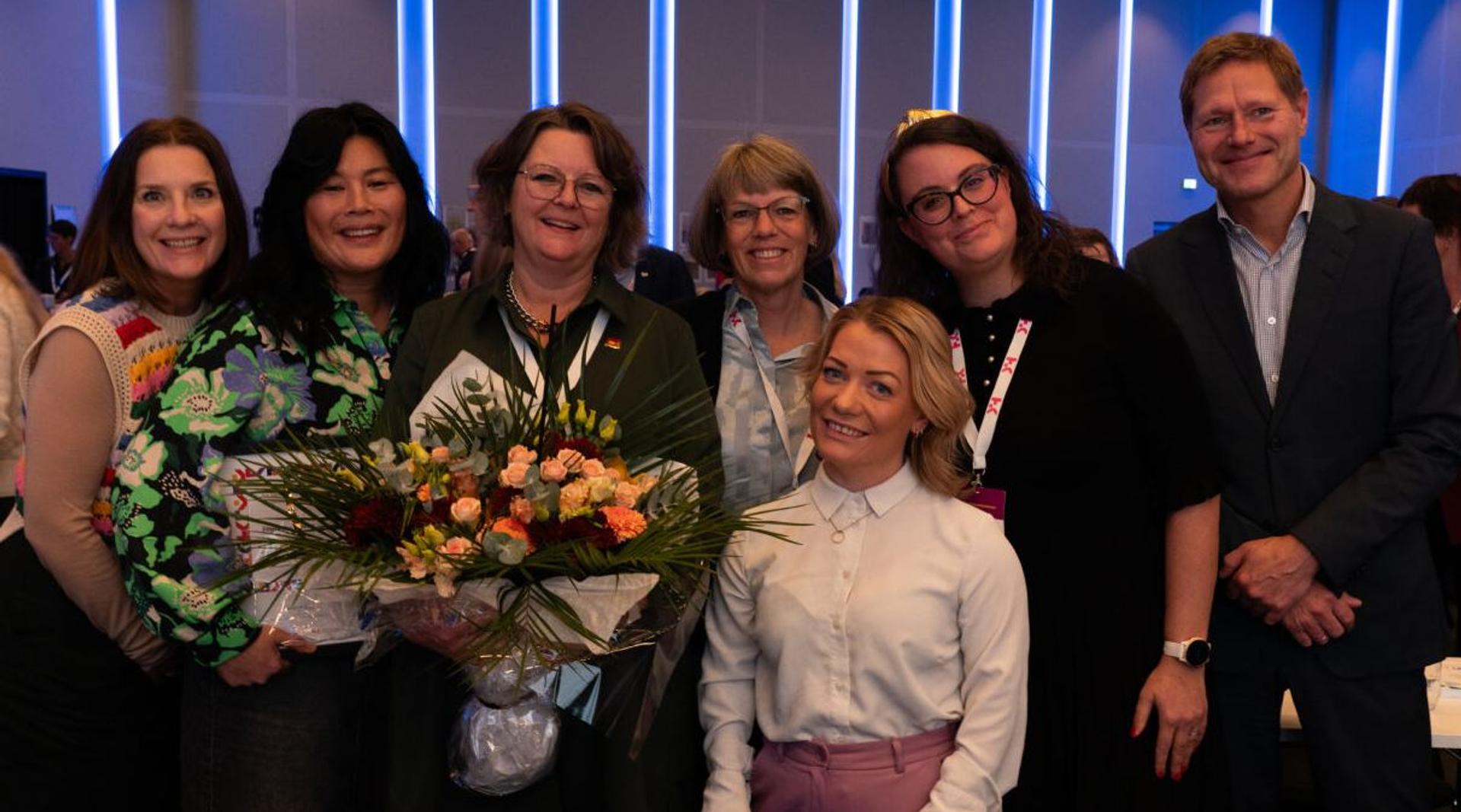 Bilde av fem smilende kvinner fra Fagskolen Kristiania, sammen med Statsråd Sandra Borch og HK-dirs direktør Sveinung Skule