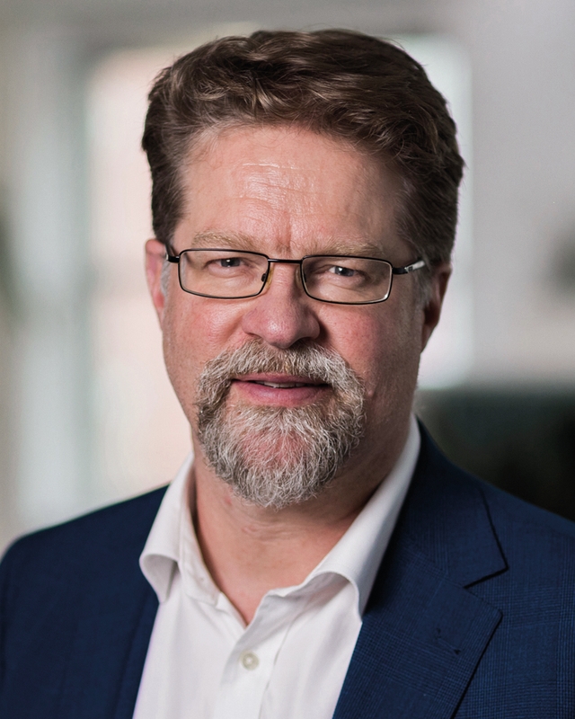 Mann som ser mot kamera