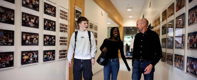 En gutt og en jente går i skolegangen med en lærer