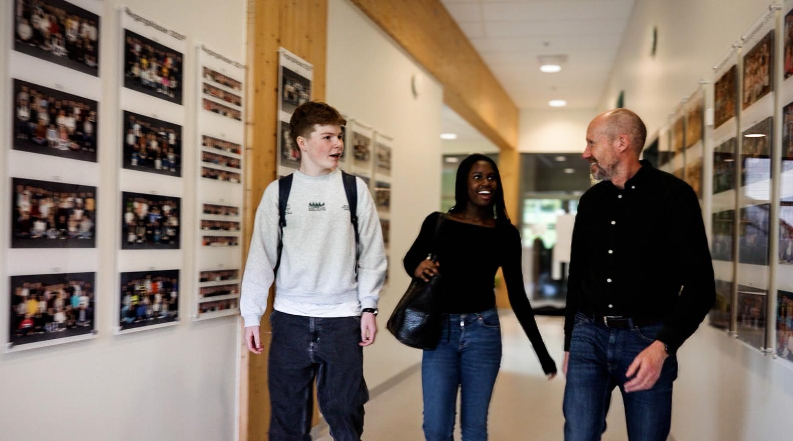 En gutt og en jente går i skolegangen med en lærer