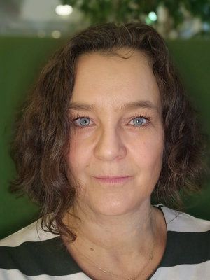 Portrett av en kvinne med mørkt, krøllete hår.