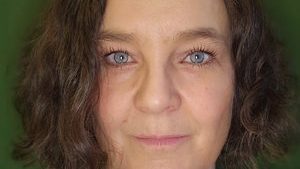 Portrett av en kvinne med mørkt, krøllete hår.