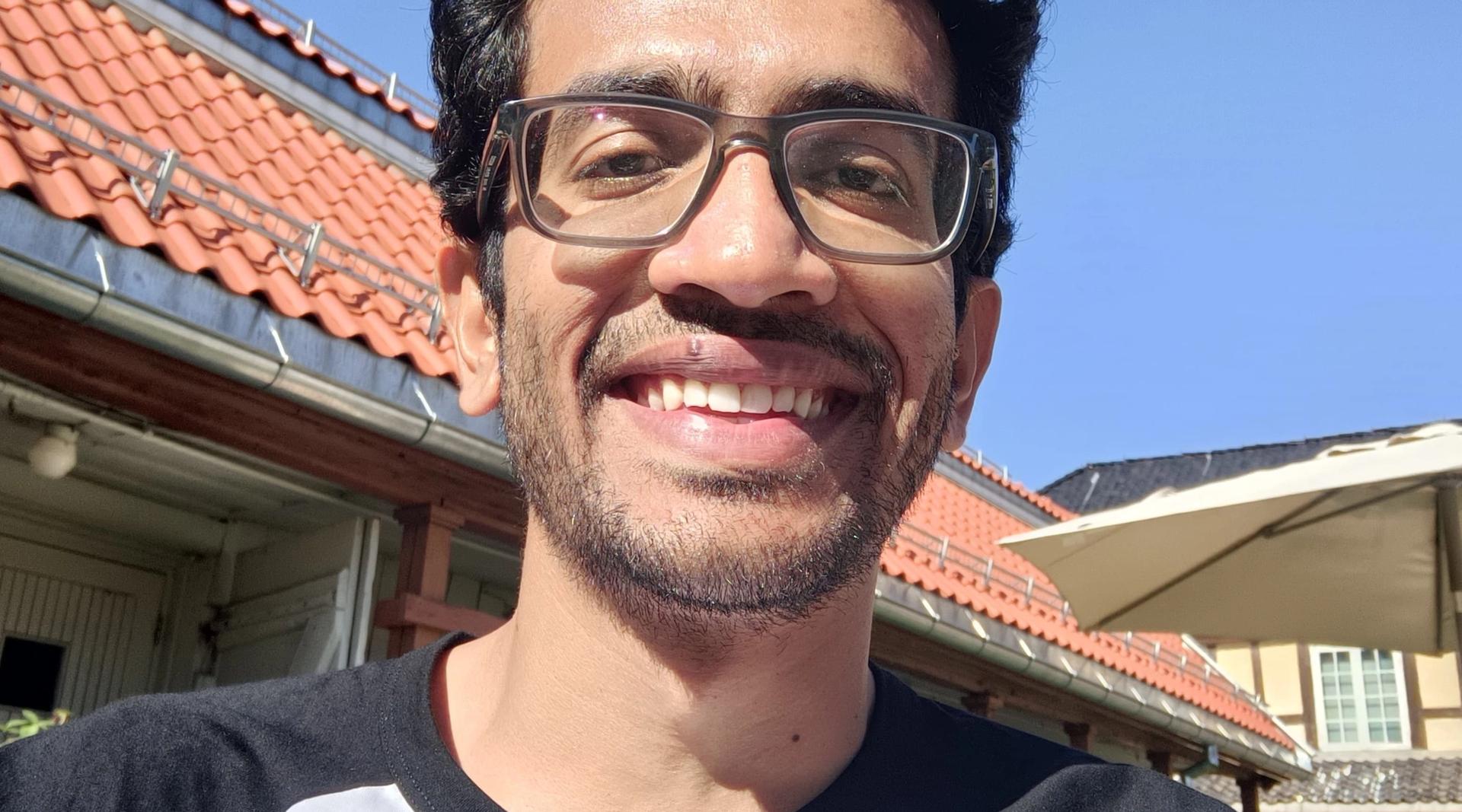 Mann som smiler mot kamera