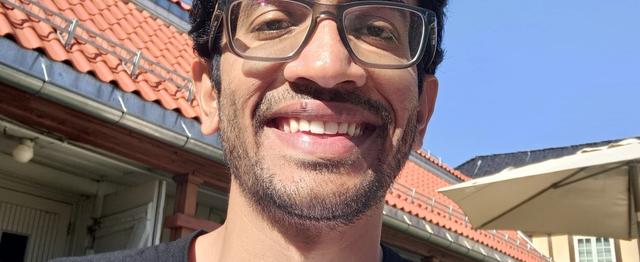 Mann som smiler mot kamera
