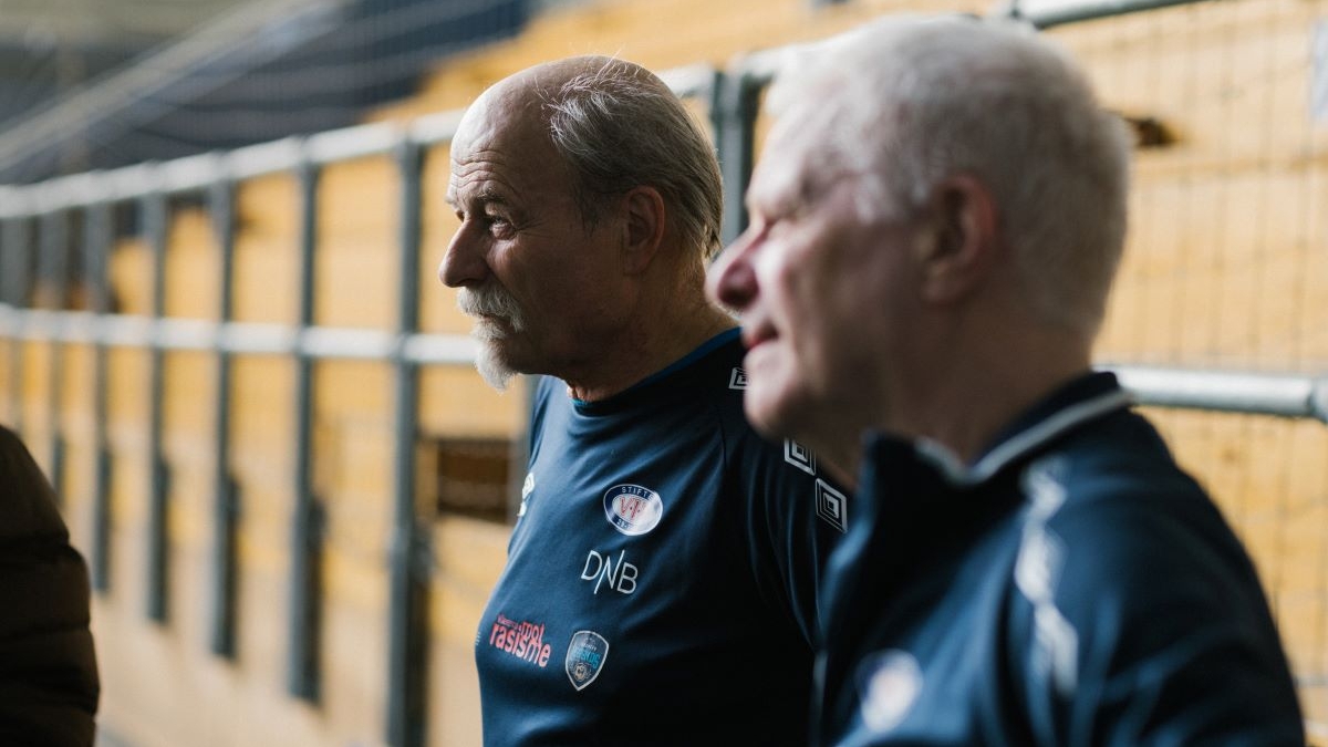 Nærbilde av to eldre menn med fotballtrøye.