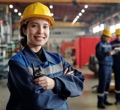 Kvinnelig industriarbeider smiler til kamera