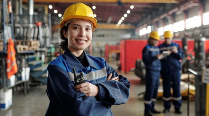 Kvinnelig industriarbeider smiler til kamera