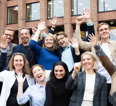 Elleve veldig glade mennesker jubler mot kamera